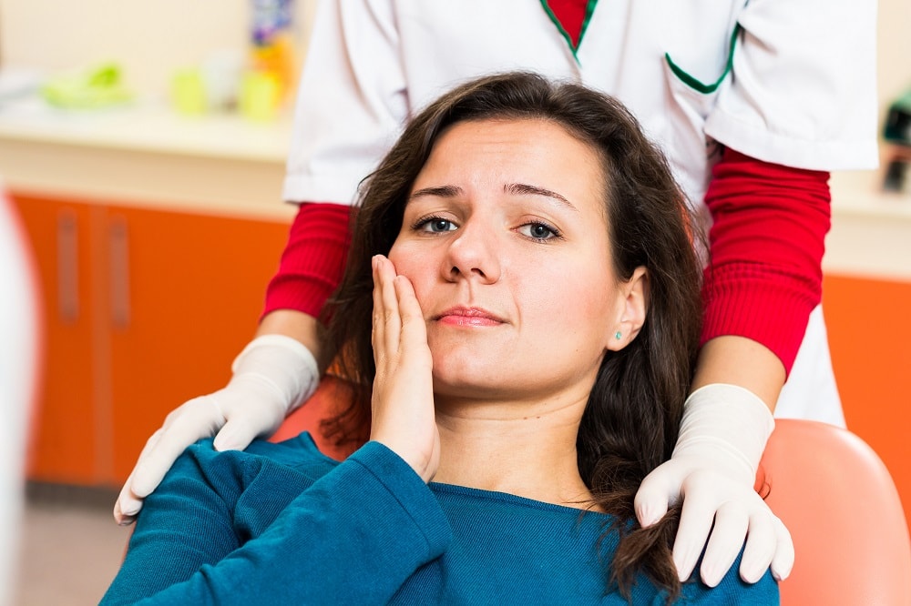 A woman in pain from tooth loss